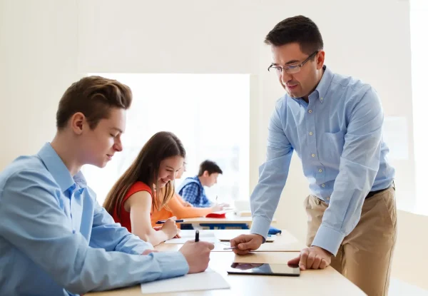 education-school-learning-teaching-people-concept-group-students-teacher-talking-classroom (1) (1)