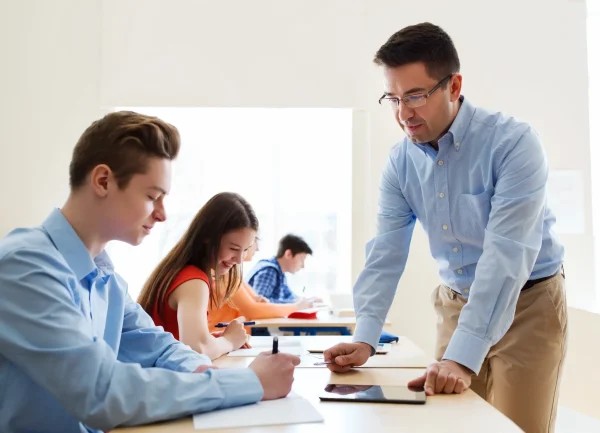 education-school-learning-teaching-people-concept-group-students-teacher-talking-classroom (1) (1)