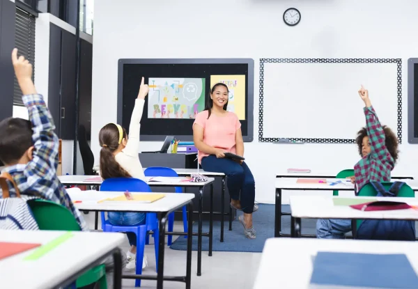 school-young-biracial-female-teacher-smiles-students-raising-hands-class (1)