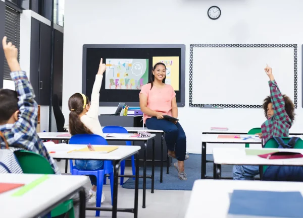 school-young-biracial-female-teacher-smiles-students-raising-hands-class (1)